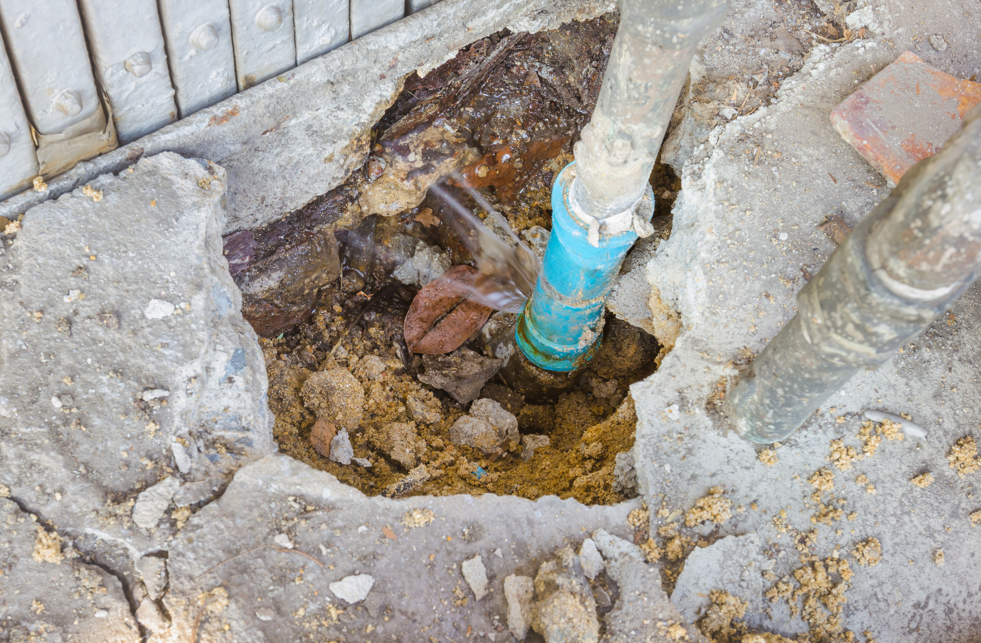 Water leaks from underground blue pipes